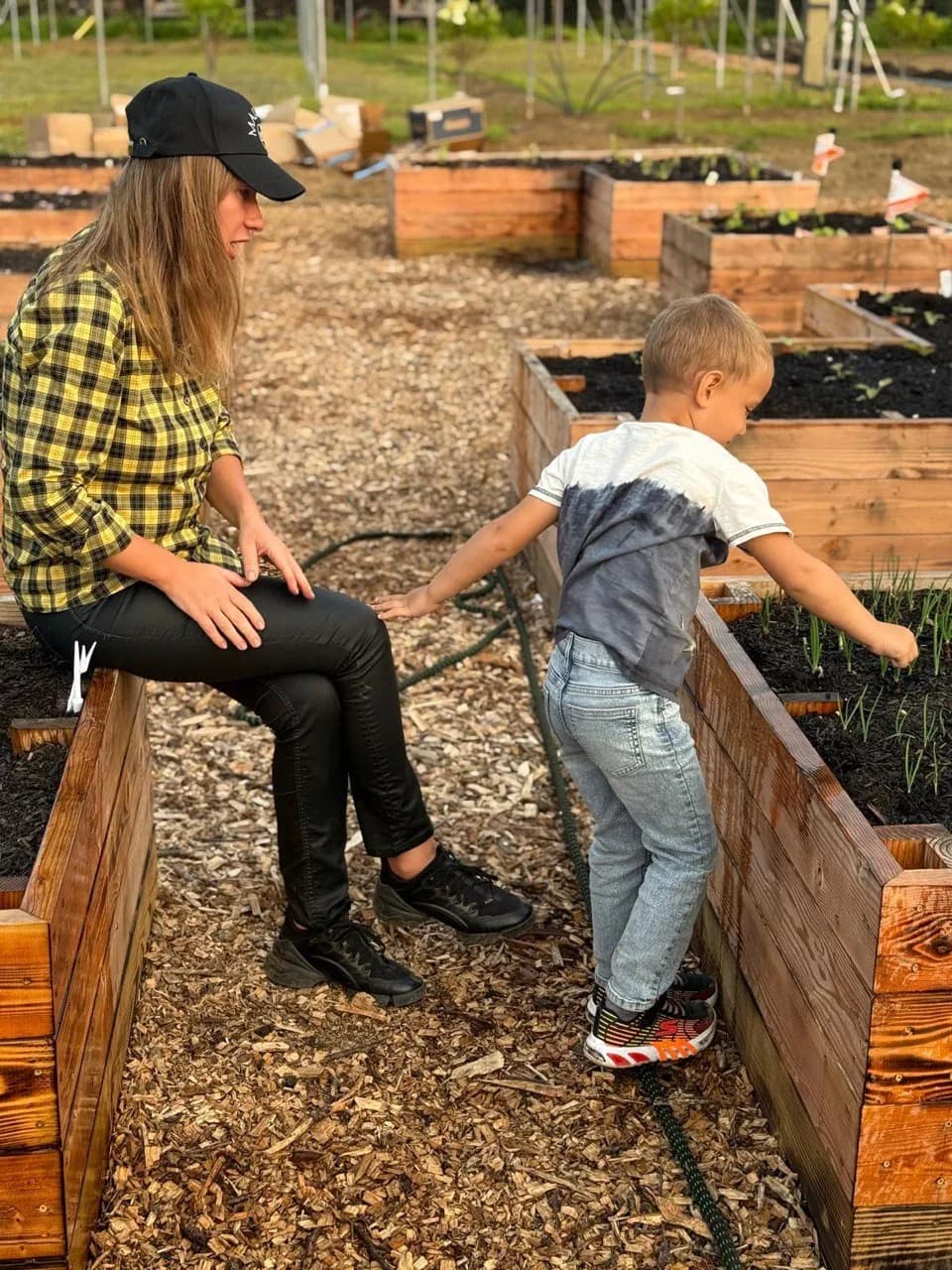 A mother and young son at the raised garden bed together