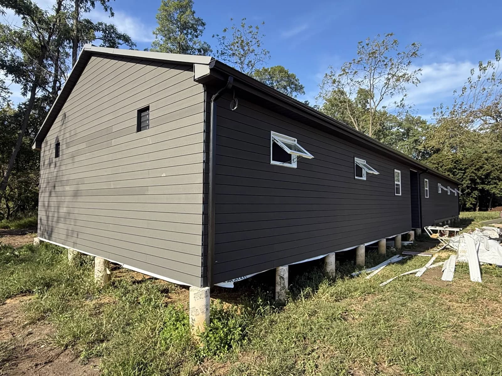 The exterior of the farm's dark-sided coop building